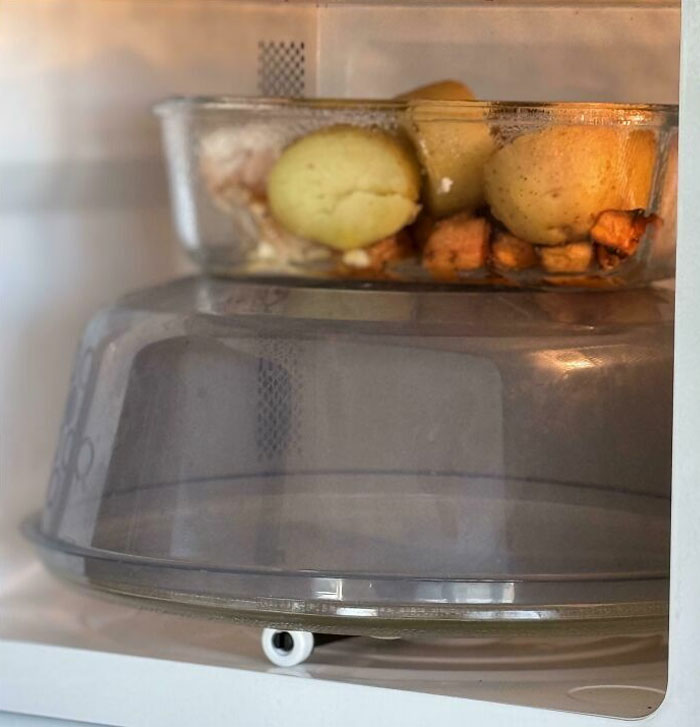 Microwave with lazy infuriating person placing food on top of turntable plate.