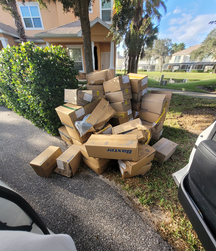 Pile of mismanaged boxes cluttering a driveway, embodying lazy-infuriating-people behavior.