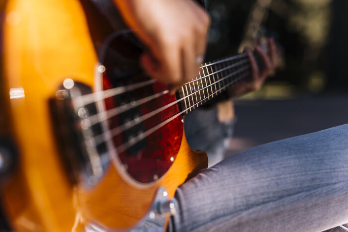 Left-handed person playing bass guitar, highlighting common struggles.