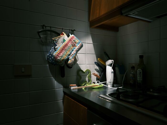 Dimly lit kitchen with utensils, highlighting left-handed people struggles.