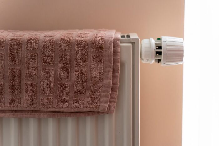 Towel hanging on a radiator, showcasing a frugal home hack for saving energy efficiently.