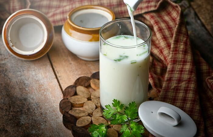 Traditional drink poured into a glass with herbs, reflecting travelers' cringeworthy culinary experiences.