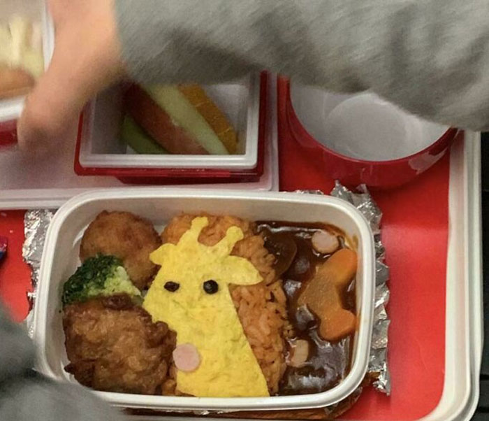 Mildly interesting bento box with giraffe-shaped omelette and colorful vegetables.