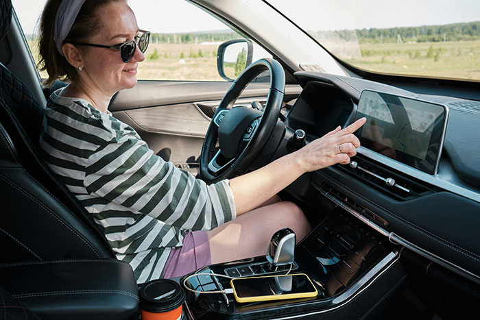 Person in striped shirt using a car's touch screen display, emphasizing challenging stereotypes and misconceptions.