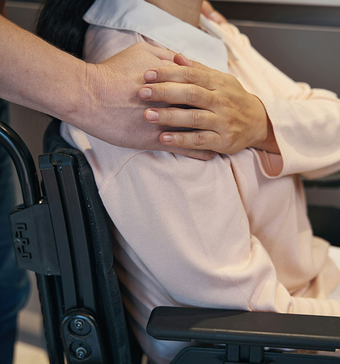 Person in a wheelchair receiving comforting touch, highlighting stereotypes and misconceptions about being "born gifted".