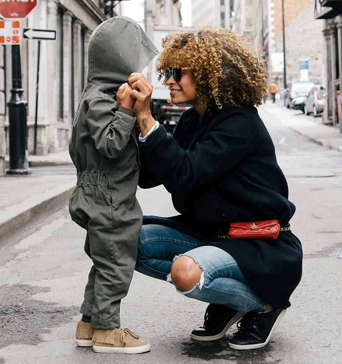 Woman and child in urban setting, challenging gifted stereotypes with a joyful interaction.