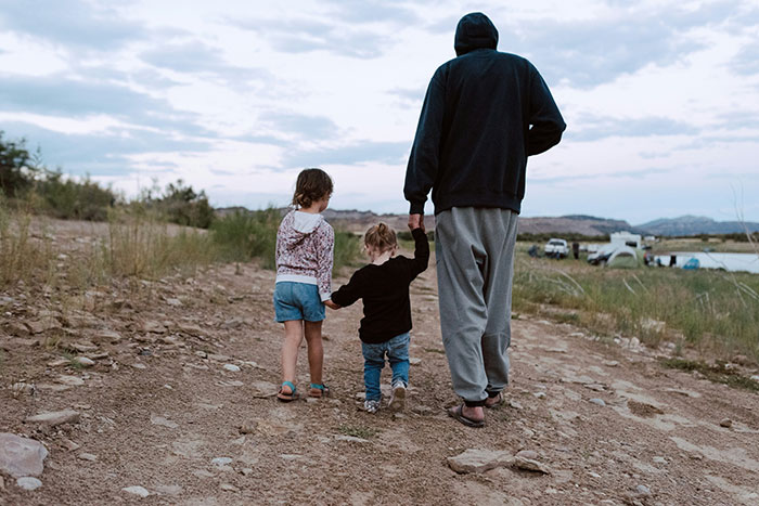 Adult and two children walking on a rocky path, challenging stereotypes and misconceptions of being "born gifted."