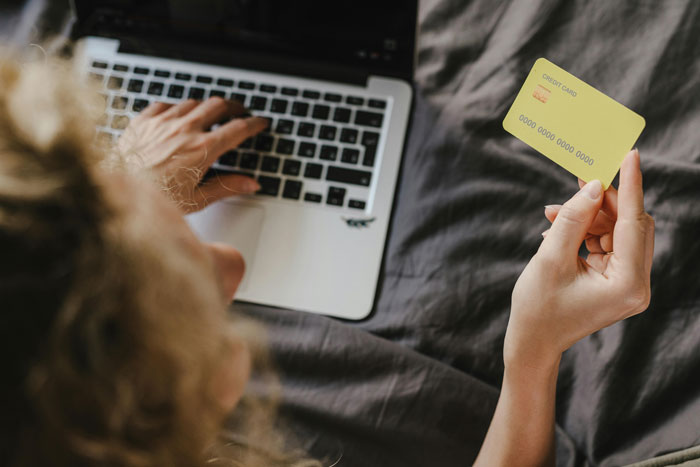 Mother handling money for family emergency on laptop.