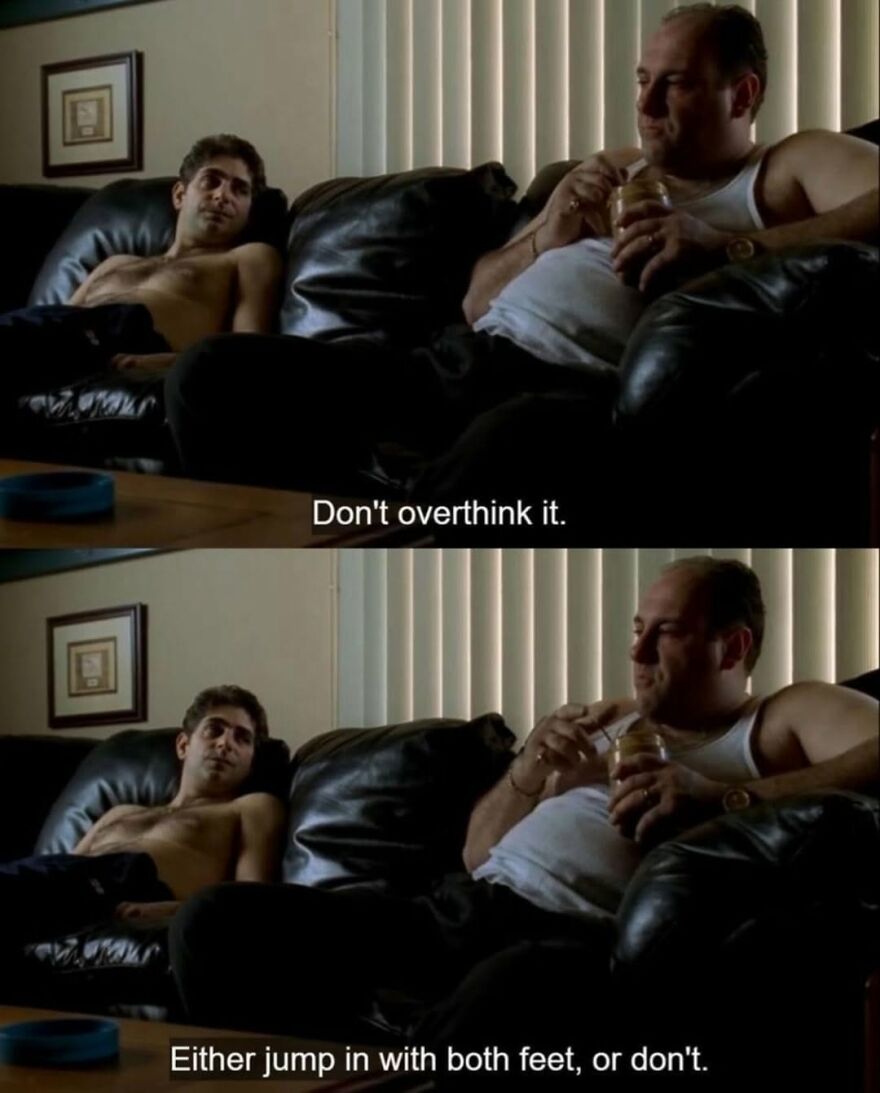 Two men sit on a couch, one shirtless, sharing iconic movie quotes.