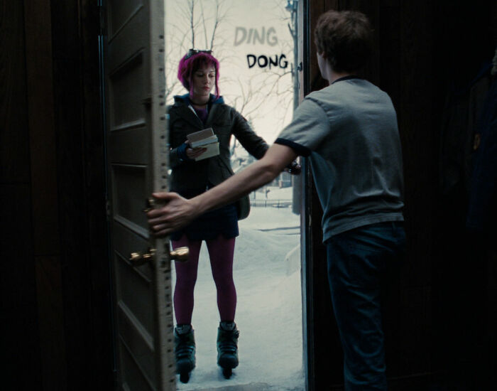 Woman on skates holding packages at a door, illustrating an awkward movie portrayal of women.