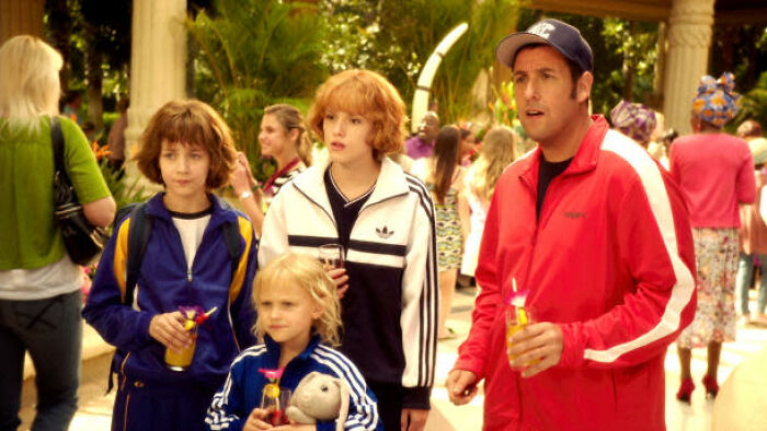 Group in brightly colored tracksuits holding drinks in a busy outdoor setting, highlighting movies' portrayal of women.