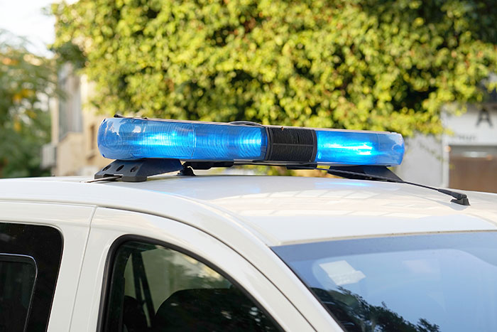 Police car with blue lights in neighborhood, related to freezing temps and neighbor incident.