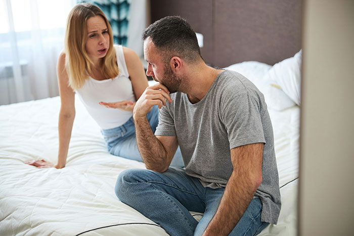 Woman and man in heated discussion, highlighting relationship challenges due to his lack of self-awareness.