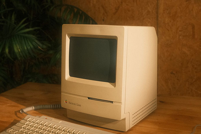 Retro beige Macintosh Classic computer on a wooden desk, symbolizing past obvious technology now confusing to some.