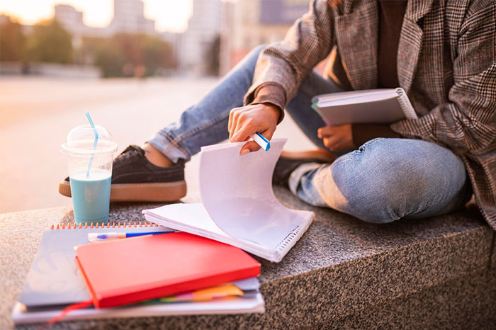 Person studying outdoors with notebooks and a drink, illustrating changing trends over 15 years.