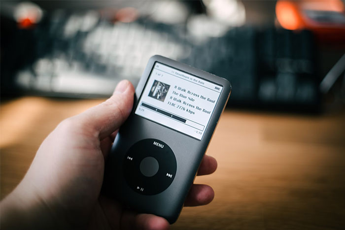 Hand holding an iPod Classic, showcasing once obvious technology from 15 years ago.