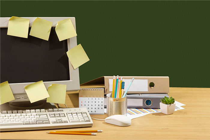 Old desktop setup with sticky notes, keyboard, and office supplies symbolizing things that used to be obvious.