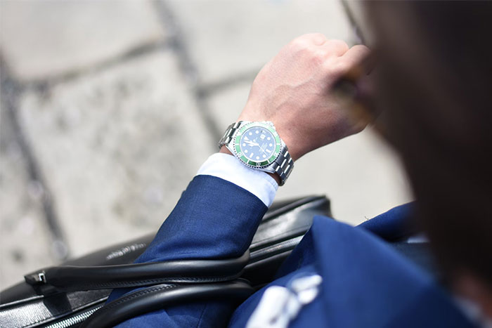 Person in a blue suit looking at a wristwatch, symbolizing confusion over time-related changes.