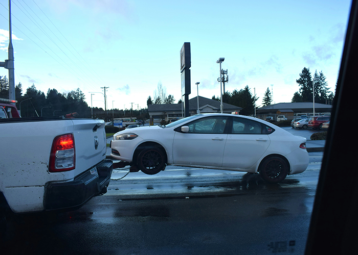 Car towed from driveway, illustrating an expensive parking lesson.