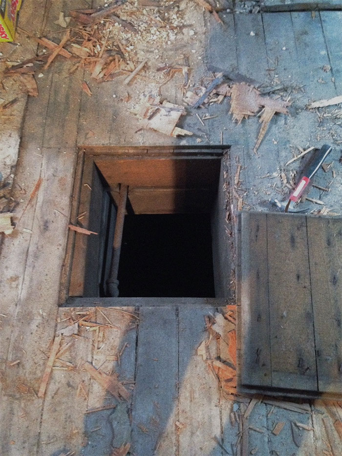 Hidden trapdoor in a wooden floor, symbolizing a lucky escape against all odds.