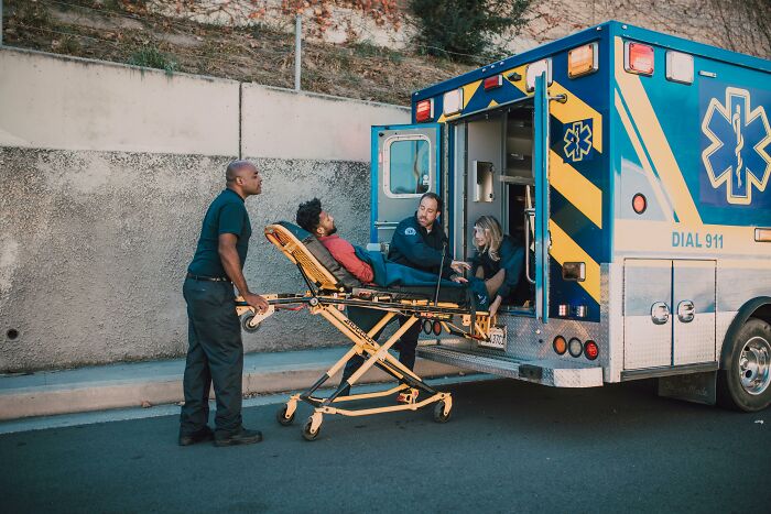 Paramedics assisting a lucky survivor into an ambulance.