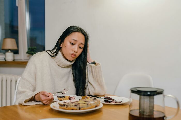 Woman enjoying peace and quiet while having breakfast alone at home.