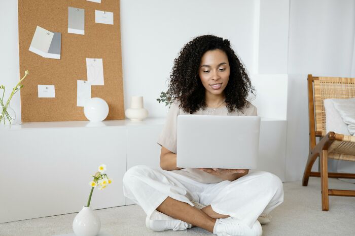 Woman enjoying peace and quiet while using a laptop in a serene home office setting.