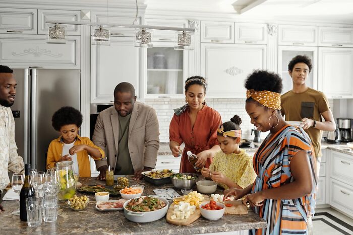 Family preparing a healthy meal together in a bright kitchen, highlighting the importance of exercise and a balanced lifestyle.