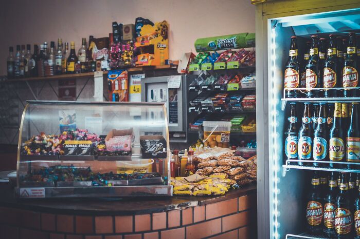 A small convenience store counter displaying snacks and drinks, suggesting a challenging job environment.