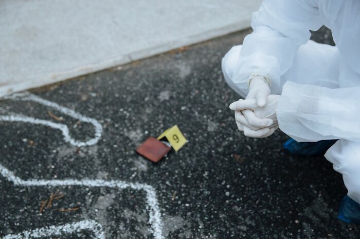 Person in protective suit examining a crime scene, highlighting the reality behind seemingly fun jobs.