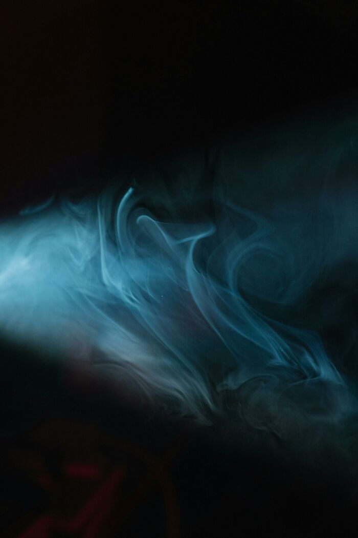 Abstract blue smoke pattern on a black background, creating a mysterious atmosphere.