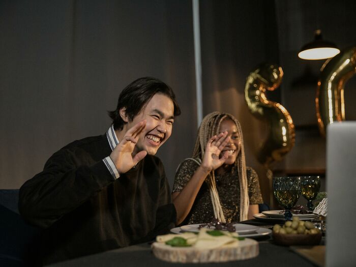 Two people waving at a virtual gathering, conveying peace and quiet during the pandemic.