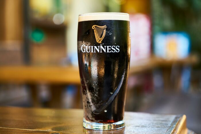 A pint of Guinness on a wooden table, highlighting rare everyday facts in a casual pub setting.