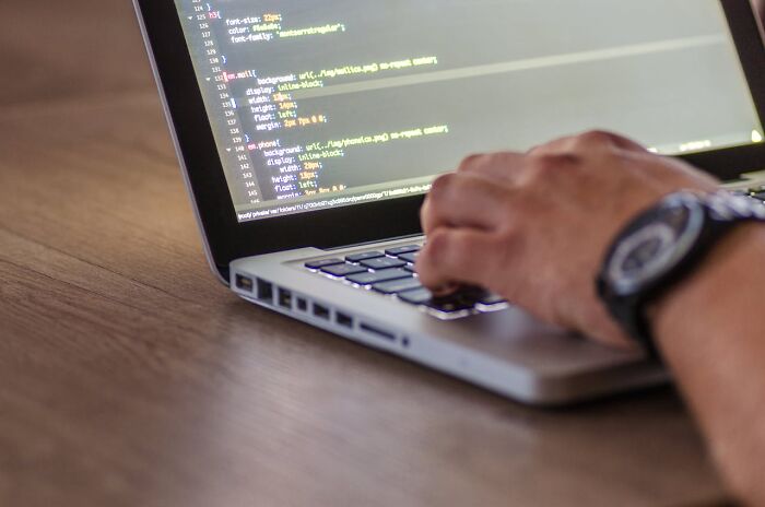 Person coding on a laptop, representing jobs perceived as fun but more challenging than imagined.