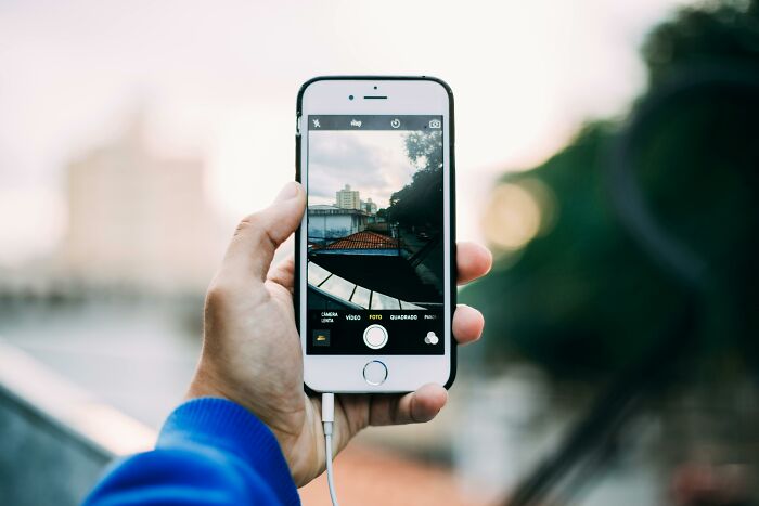 Hand holding a smartphone capturing a scenic city view, illustrating rare everyday facts.