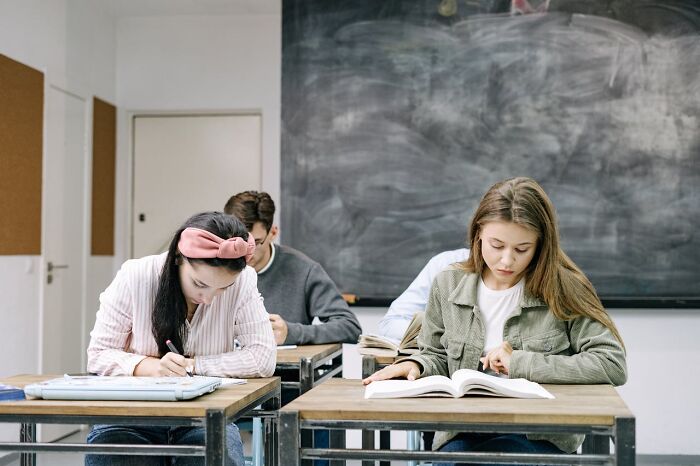 Students in a classroom focusing intently on assignments, highlighting undisclosed job secrets.