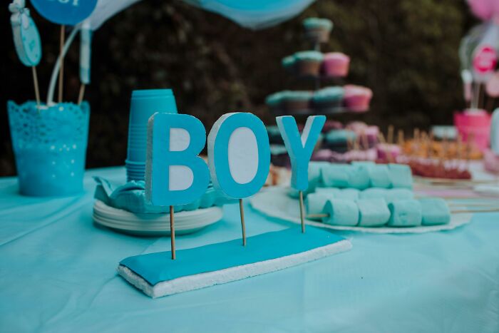 Blue-themed party table with marshmallows and a "BOY" sign, illustrating WomenInMaleFields celebration.