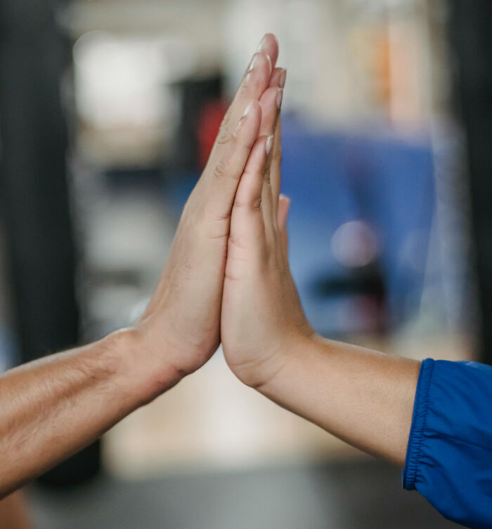 Two people giving each other a high-five, symbolizing a shared moment in travel situations.