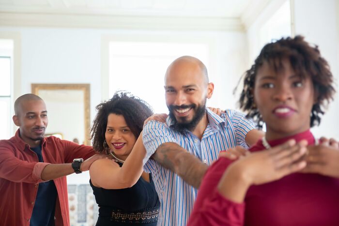 Group of people enjoying a moment of connection, smiling and relaxed indoors, capturing a sense of peace and quiet.