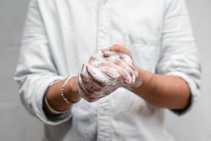 Person washing hands with soapy lather, demonstrating essential hygiene habits.