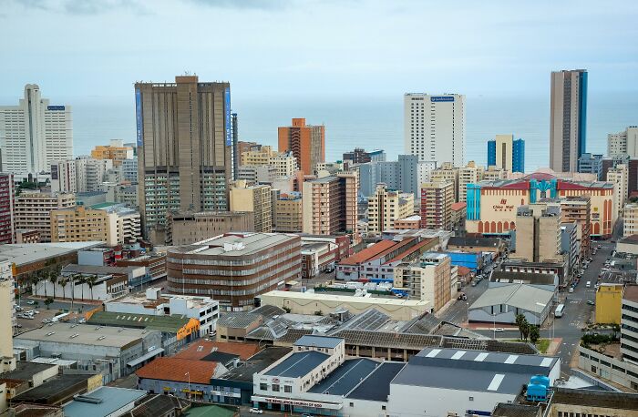 A vibrant cityscape with tall buildings by the ocean, illustrating how the world feels smaller through coincidences.