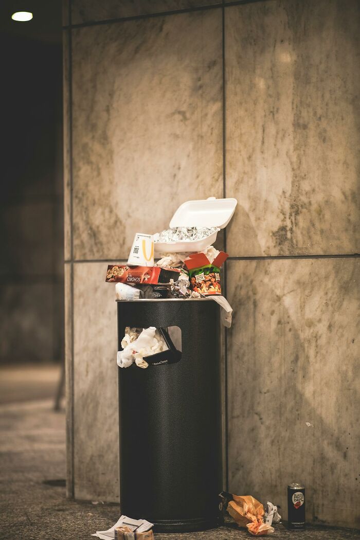 Overflowing trash bin at a casino, revealing behind-the-scenes mess not usually seen.