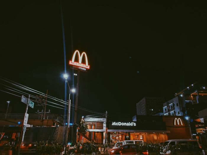 Night view of McDonald's drive-thru, showcasing its iconic lit-up signage.