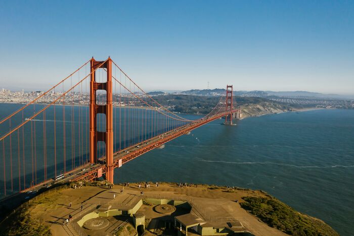 Golden Gate Bridge spanning blue waters under a clear sky, capturing a rare everyday scene.