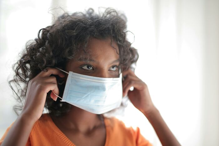 A person wearing a face mask at home during the pandemic.