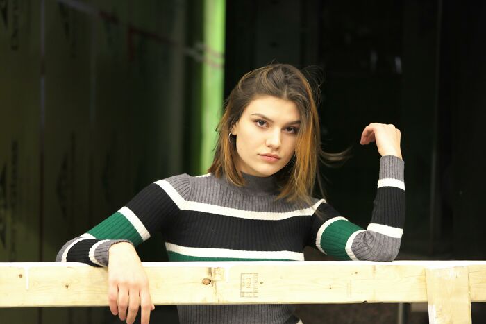 Woman confidently posing at a construction site, highlighting WomenInMaleFields trend.