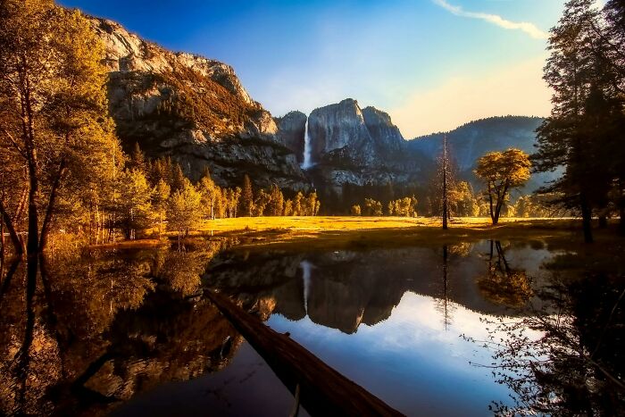 Peace and quiet in serene nature with mountains, trees, and a reflective lake under a clear sky.