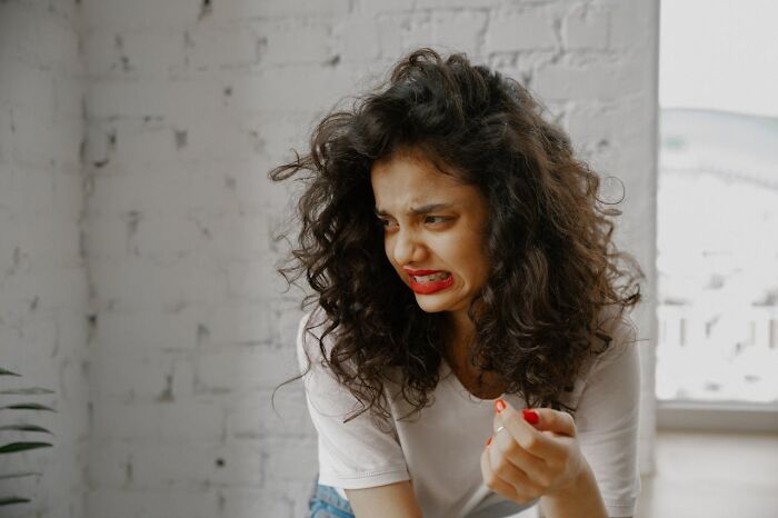 Woman reacting to an unpleasant odor, emphasizing the importance of proper hygiene habits.