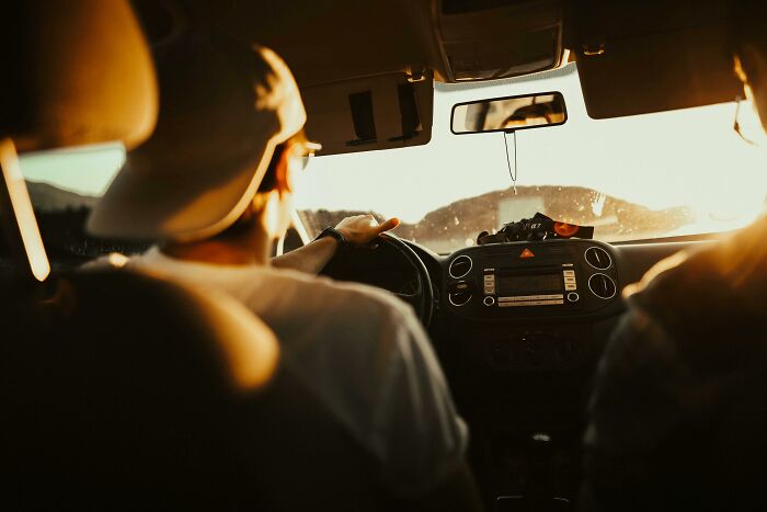 Person driving a car at sunset, experiencing an astonishing coincidence.