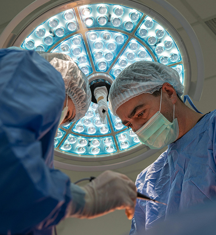 Doctors performing surgery under bright surgical lights.